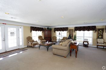 A living room with a sofa, armchairs, and a coffee table.